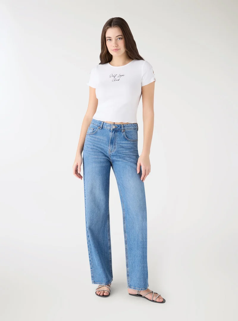T-shirt crop con scritta e fiocchi
