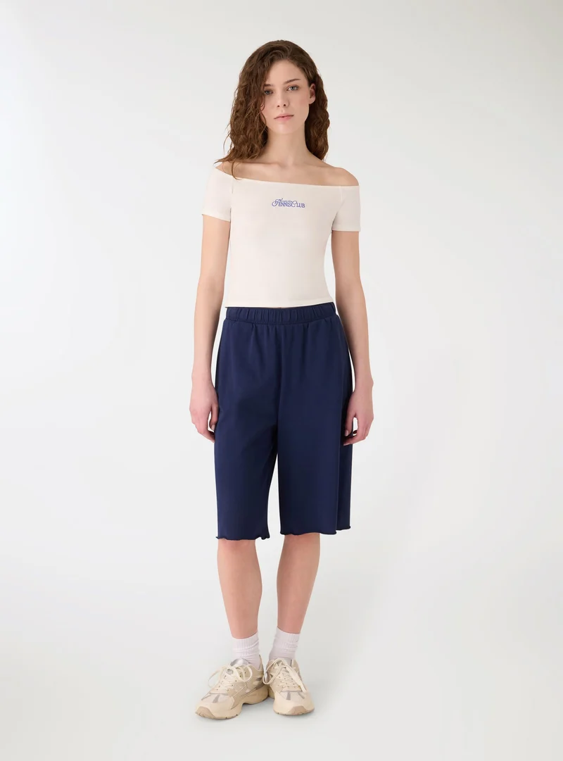 T-shirt con spalle scoperte e ricamo college
