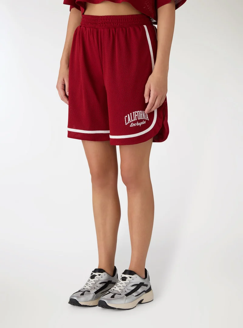 Shorts sportivi in rete con stampa college
