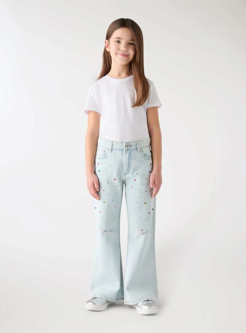 Jeans a zampa con strass e strappi