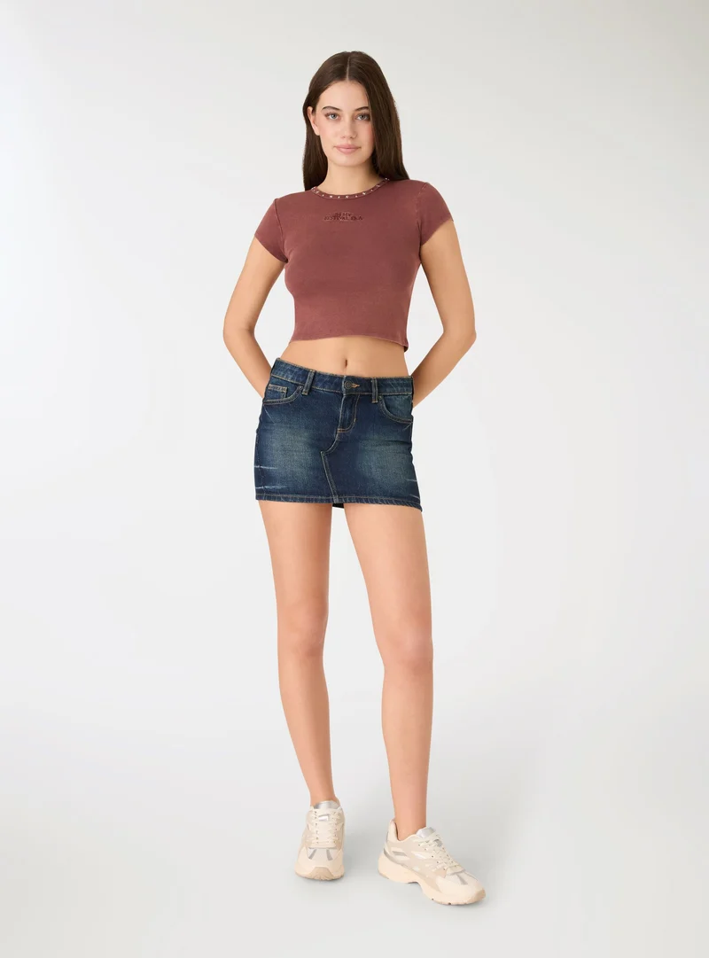 T-shirt crop con borchie e scritta