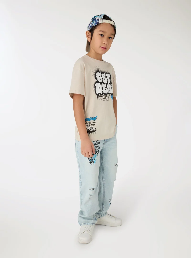 Jeans con stampa graffiti e strappi
