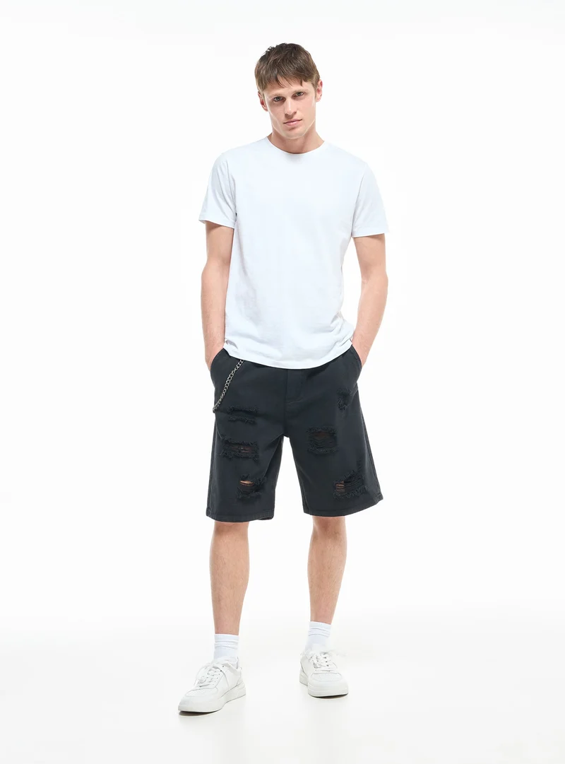 Pantaloncini con strappi e catena