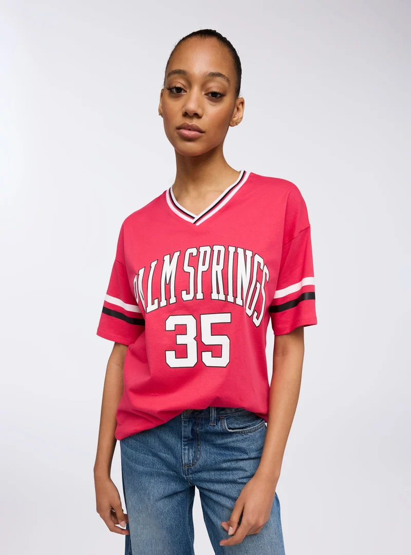 T-shirt maxi con scollo v stampa college