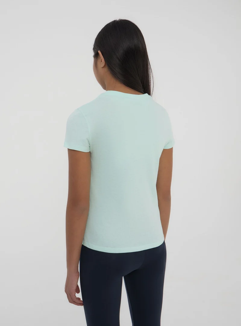 T-shirt tinta unita con etichetta sulla manica
