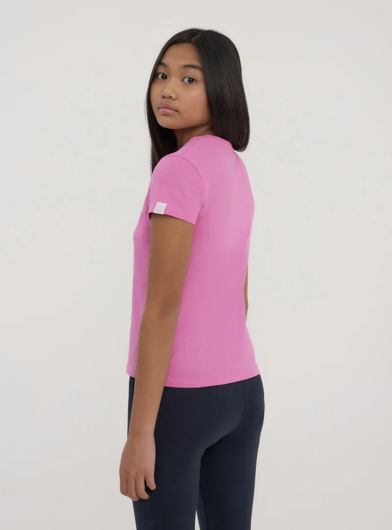 T-shirt tinta unita con etichetta sulla manica