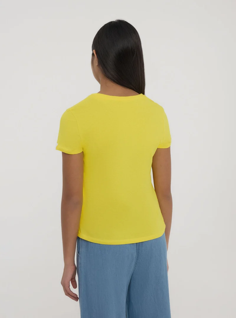 T-shirt tinta unita con etichetta sulla manica