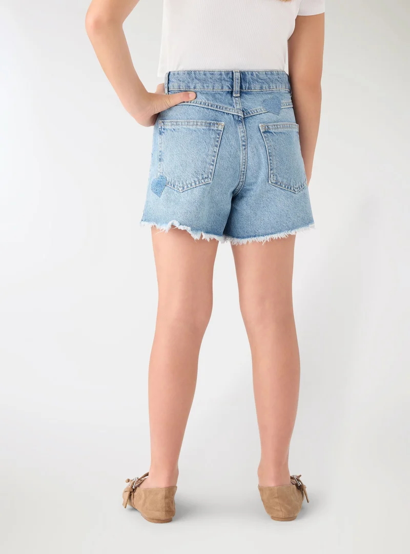 Shorts in denim con stampa cuori e borchie