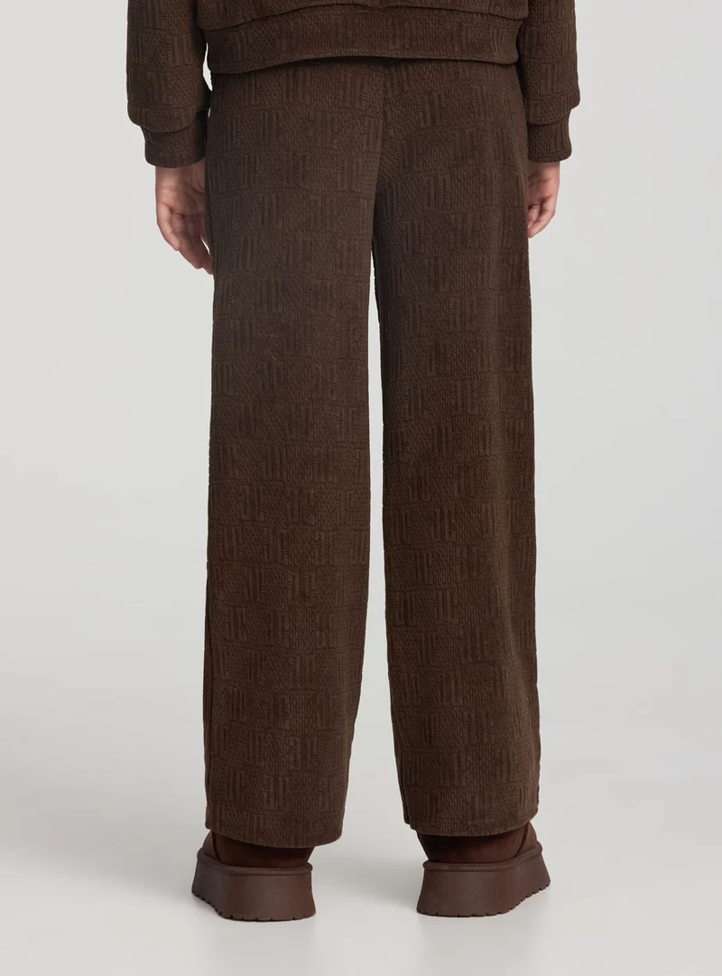 Pantaloni tuta wide leg con lavorazione goffrata