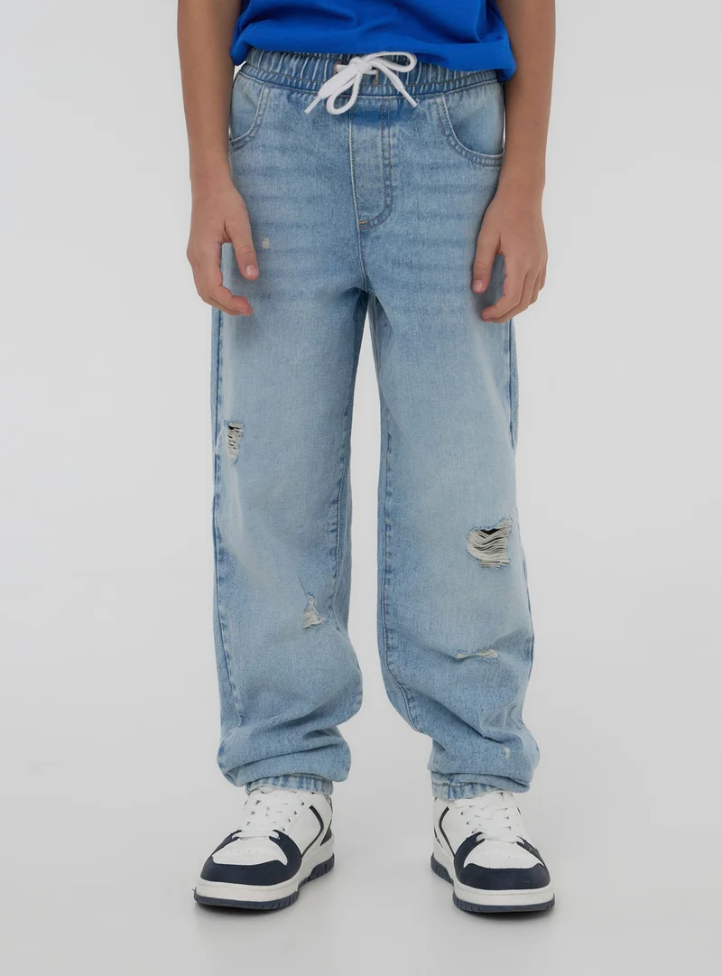 Jogger in denim con strappi e coulisse