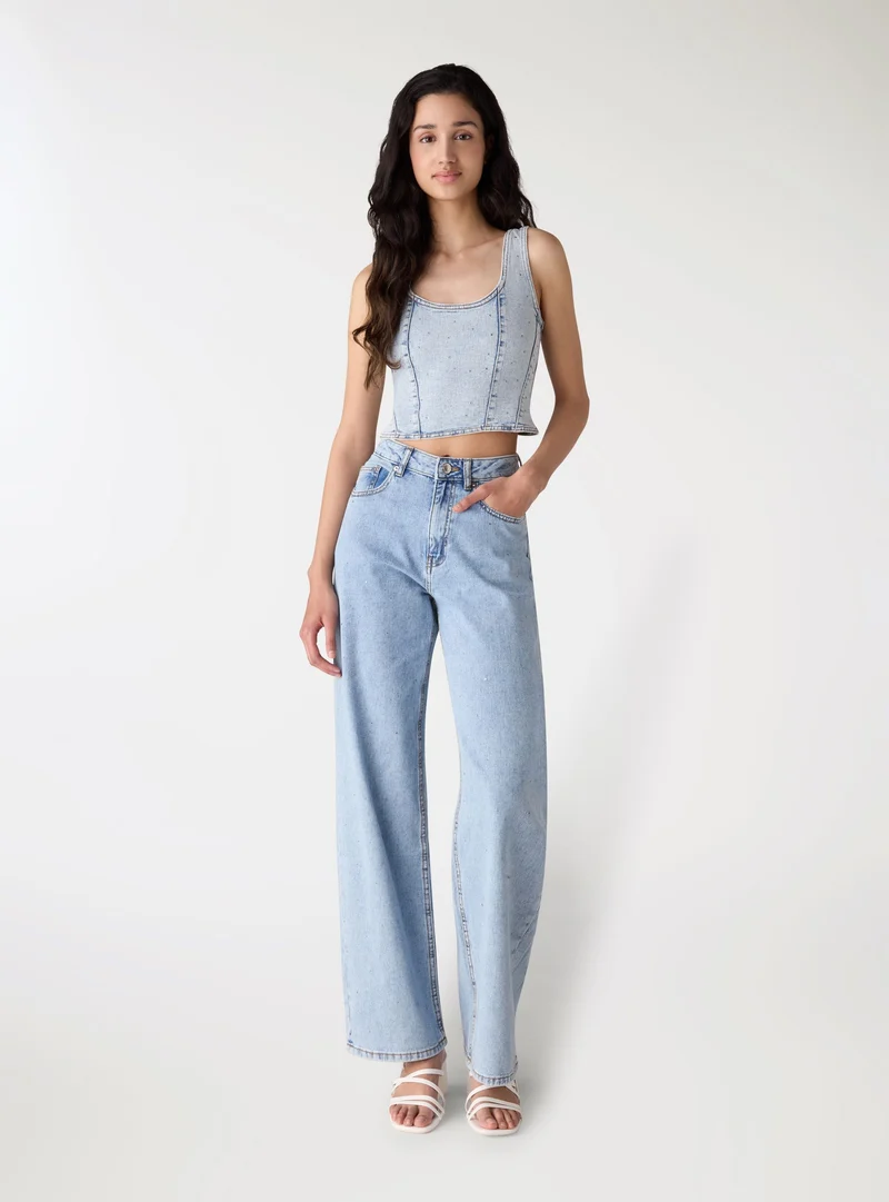 Jeans wide leg con strass allover