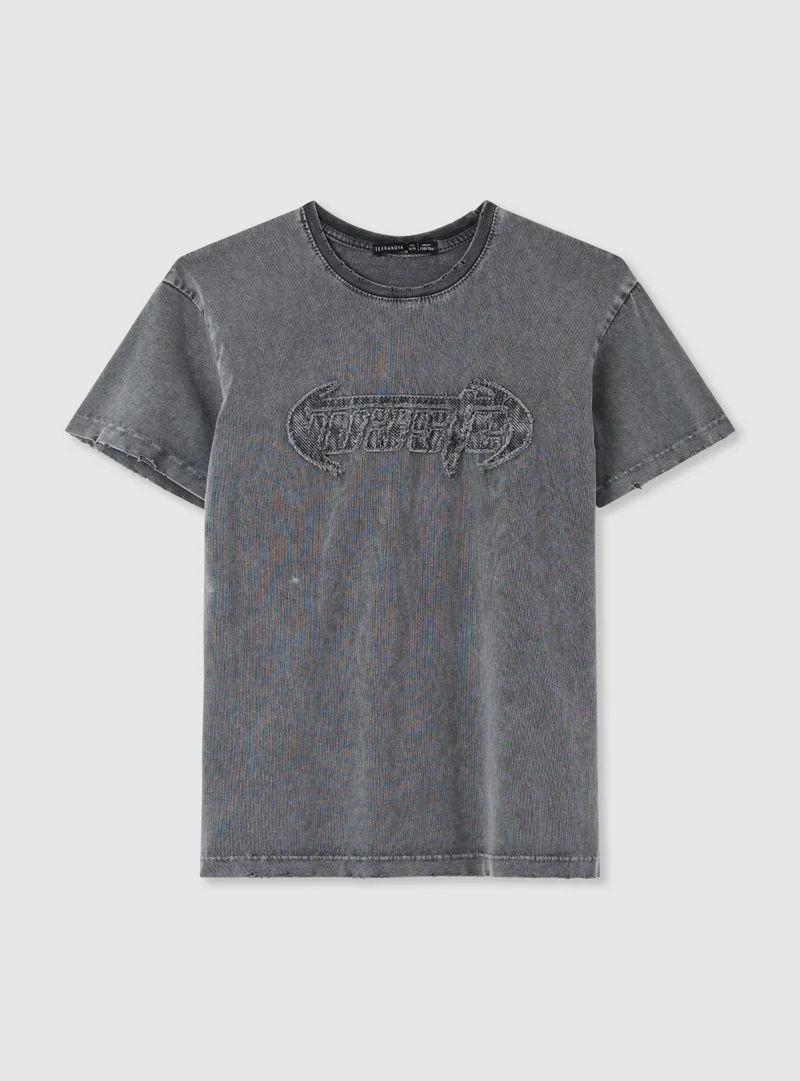 T-shirt con patch e strappi