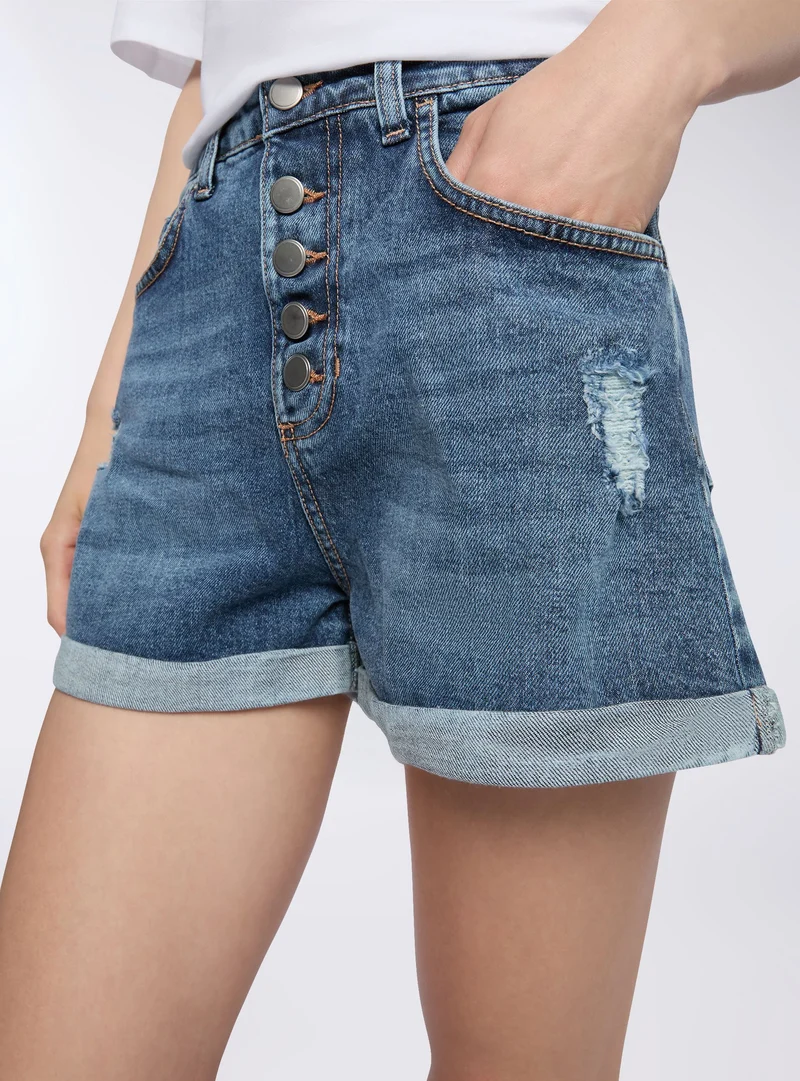 Shorts di jeans con strappi e bottoni