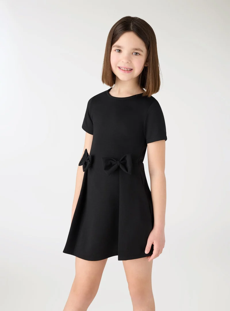 Vestito a tinta unita con fiocchi