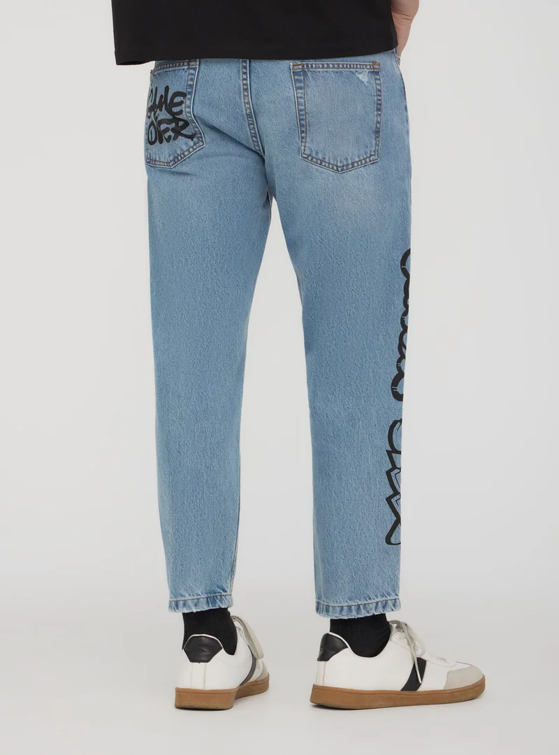 Jeans loose graffiti con strappi
