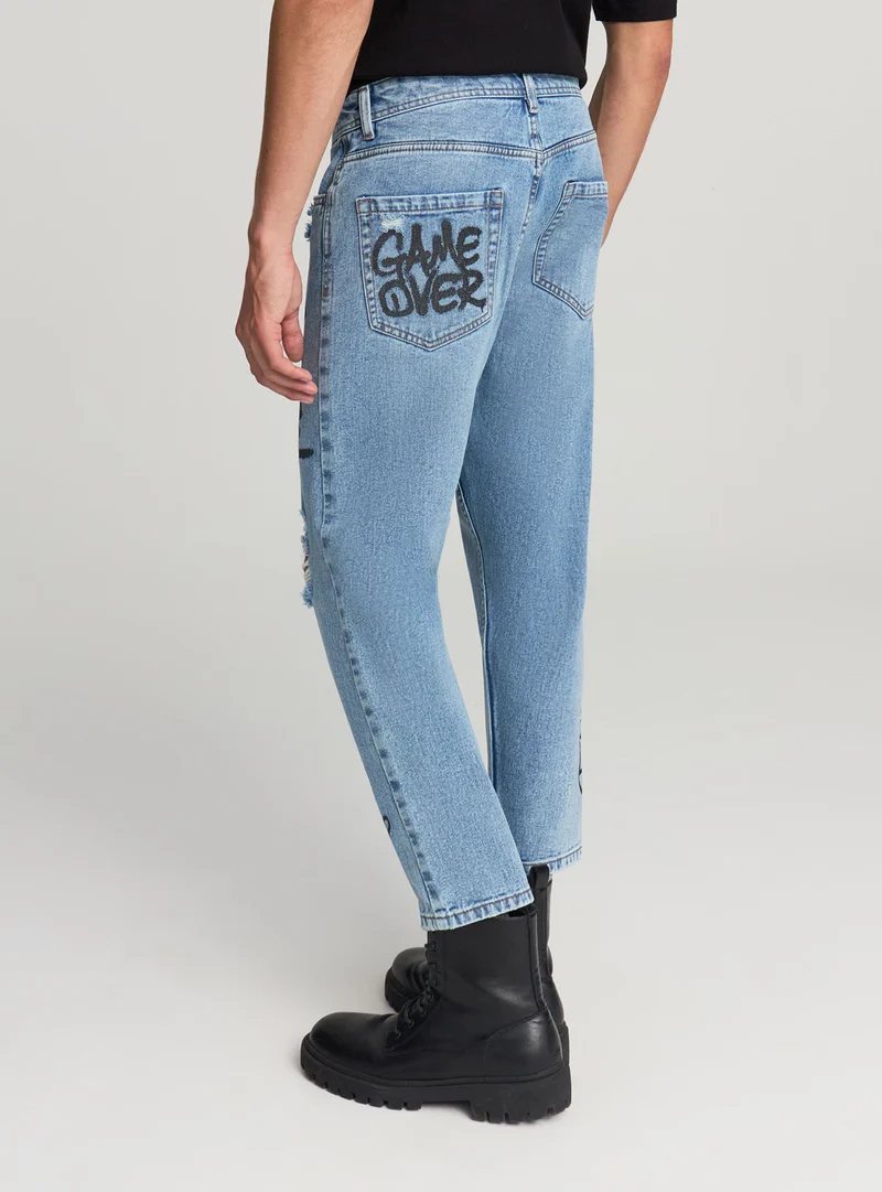 Jeans loose fit con graffiti e strappi